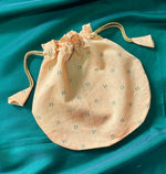 Load image into Gallery viewer, Flat-lay of beige butti embroidered potli with cord drawstring