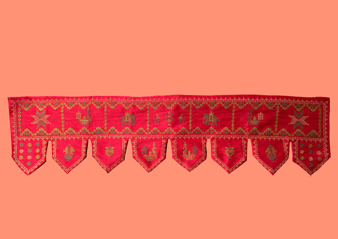 Close-up of red kubera toran showing embroidered motifs