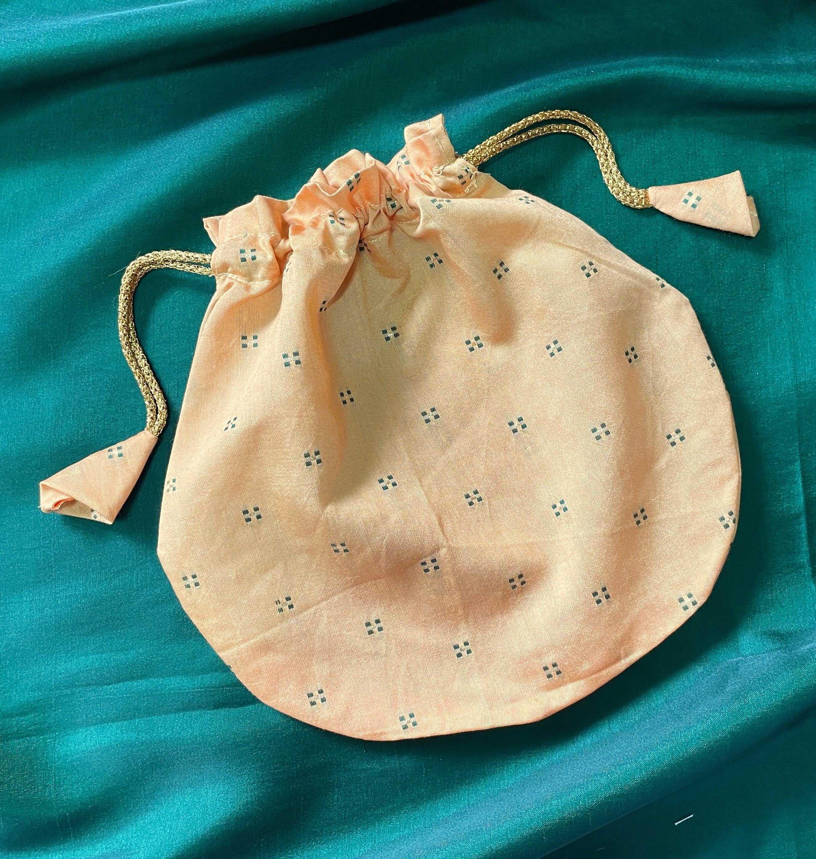 Sea green butti potli side view with embroidered motifs and tassels