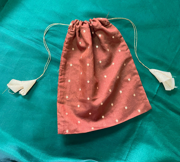 Pink potli with floral embroidery and decorative drawstring closure