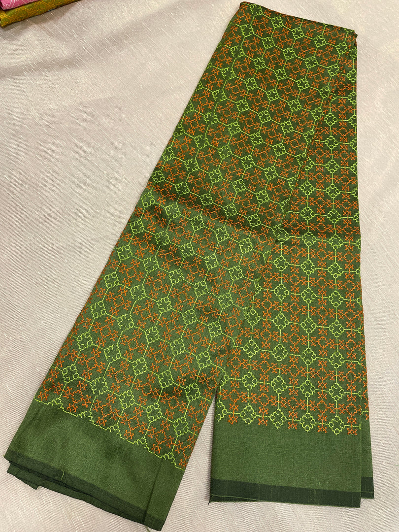 Close-up of kasuti floral embroidery on mehendi green fabric