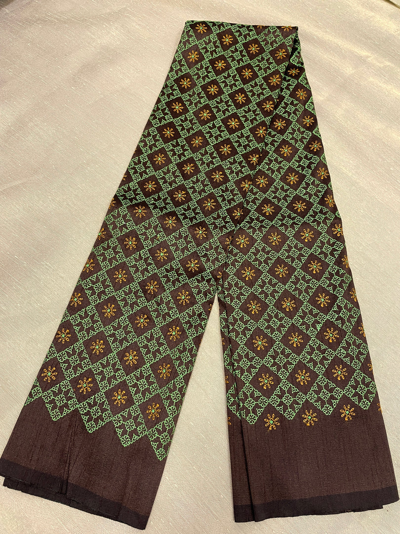 Hand embroidery close-up on coffee brown kasuti blouse fabric