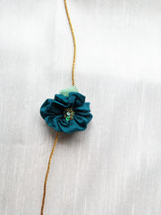 Mid blue kasuti rakhi with intricate embroidery close-up