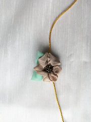 Beige kasuti rakhi with embroidered thread design