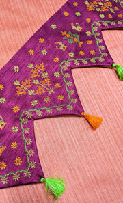 Magenta pink kasuti toran shown with hanging embroidery