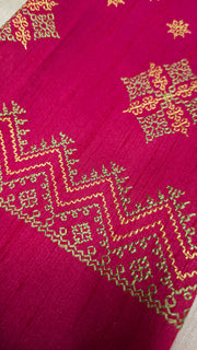 Angled side of rani pink blouse showing kasuti embroidery