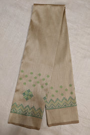 Angled side view of beige blouse showing kasuti embroidered motifs