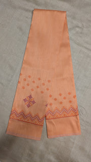 Angled side view of pink peach blouse featuring kasuti threadwork
