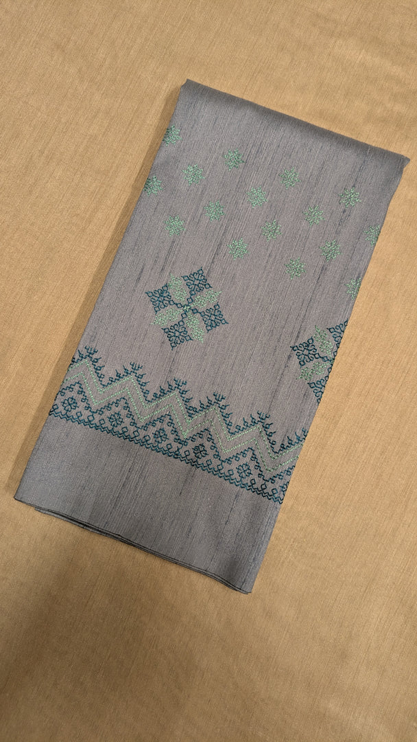 Close-up of embroidered motifs on grey kasuti blouse fabric