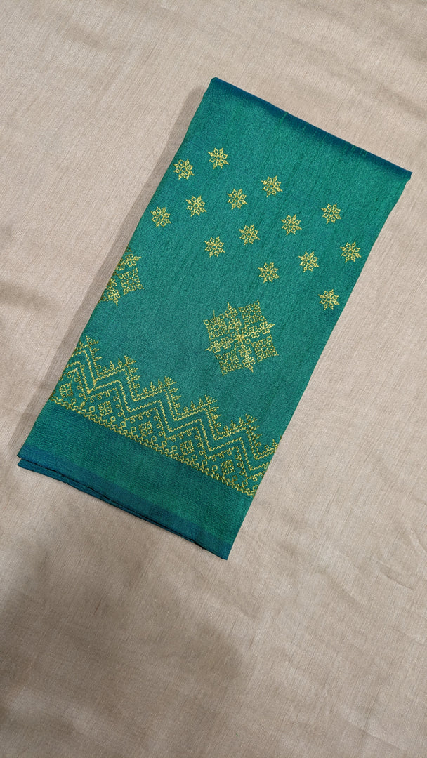 Close-up embroidery detail on emerald green kasuti blouse fabric