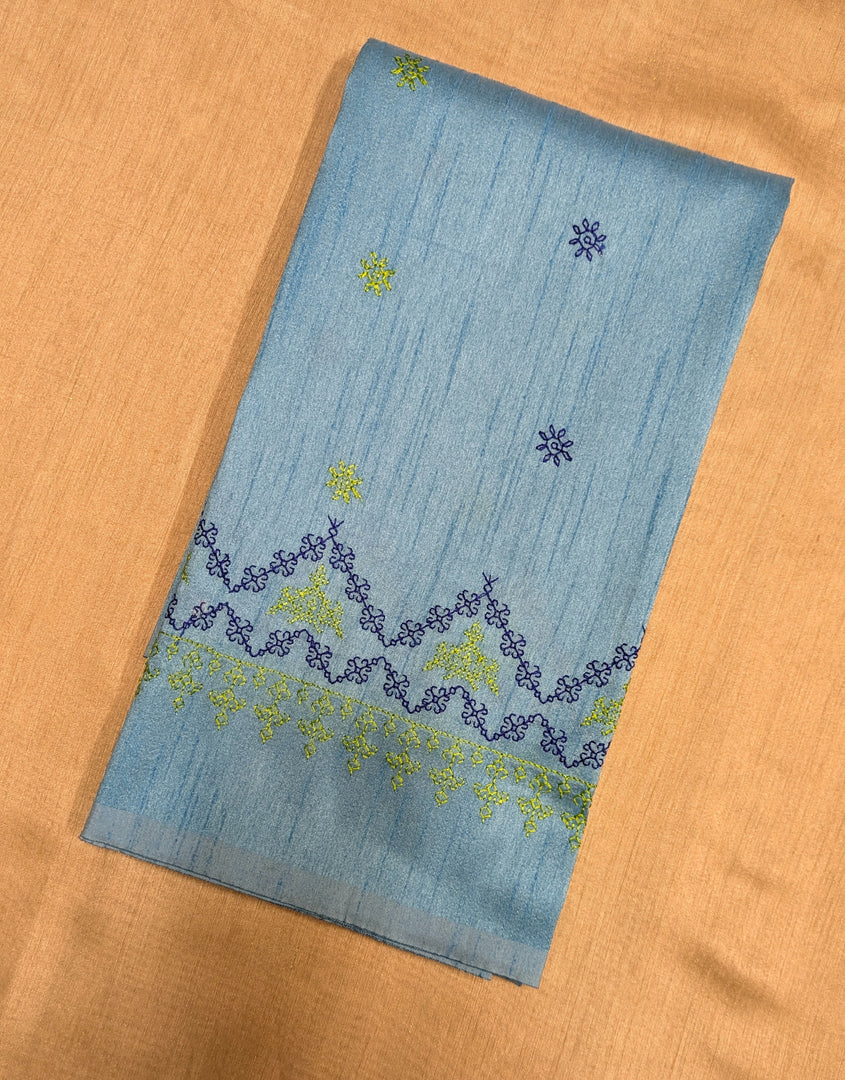 Close-up embroidery detail on sky blue kasuti blouse fabric