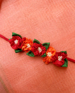 Load image into Gallery viewer, Red orange handcrafted fabric gajra hairtie close-up with floral fabric work
