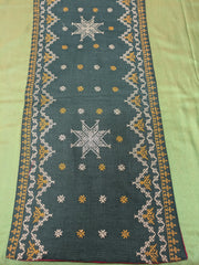 Green table runner with woven cotton texture and hand-finished edges