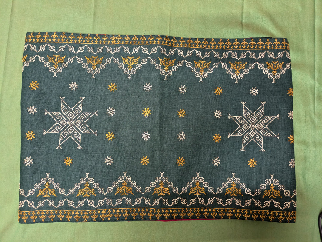 Green cotton table runner fabric showing detailed weave texture