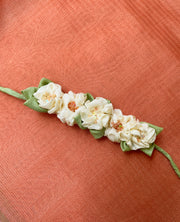 White handcrafted fabric gajra hairtie close-up with floral fabric detail